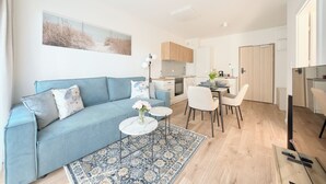 Een moderne woonkamer met een bank, een eettafel en stoelen.