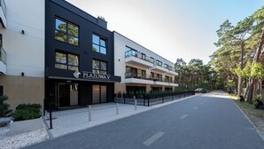 Een meerlaags gebouw met een bord waarop 'PLAZOWAV' staat.