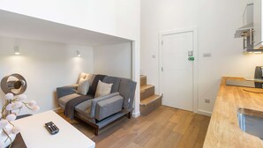 Ein modernes Wohnzimmer mit Sofa, Couchtisch und Fernbedienung.