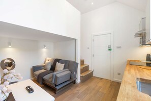 Ein modernes Wohnzimmer mit Sofa, Couchtisch und Fernbedienung.