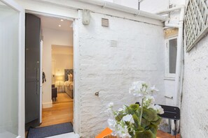 A narrow corridor with a door leading to a bedroom. - Primrose Hill 1BR Flat - Private Patio (Greater London)