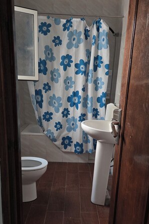 A bathroom with a shower curtain, a sink, and a toilet. - Coffee baba Chefchaouen (Chefchaouen)