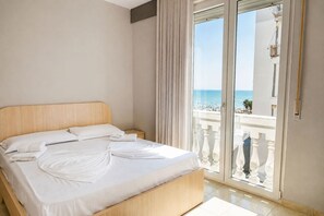 A hotel room with a large bed, a view of the sea through a balcony, and a modern design. - Illyrian Apartment 05 (Durrës)