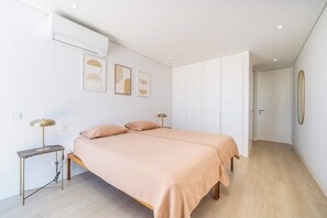Ein modernes Schlafzimmer mit Bett, Nachttischen und Kunstwerken an der Wand.