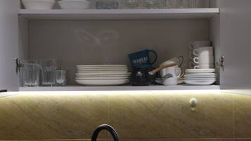 A kitchen with a black sink, a soap dispenser, and a coffee machine.