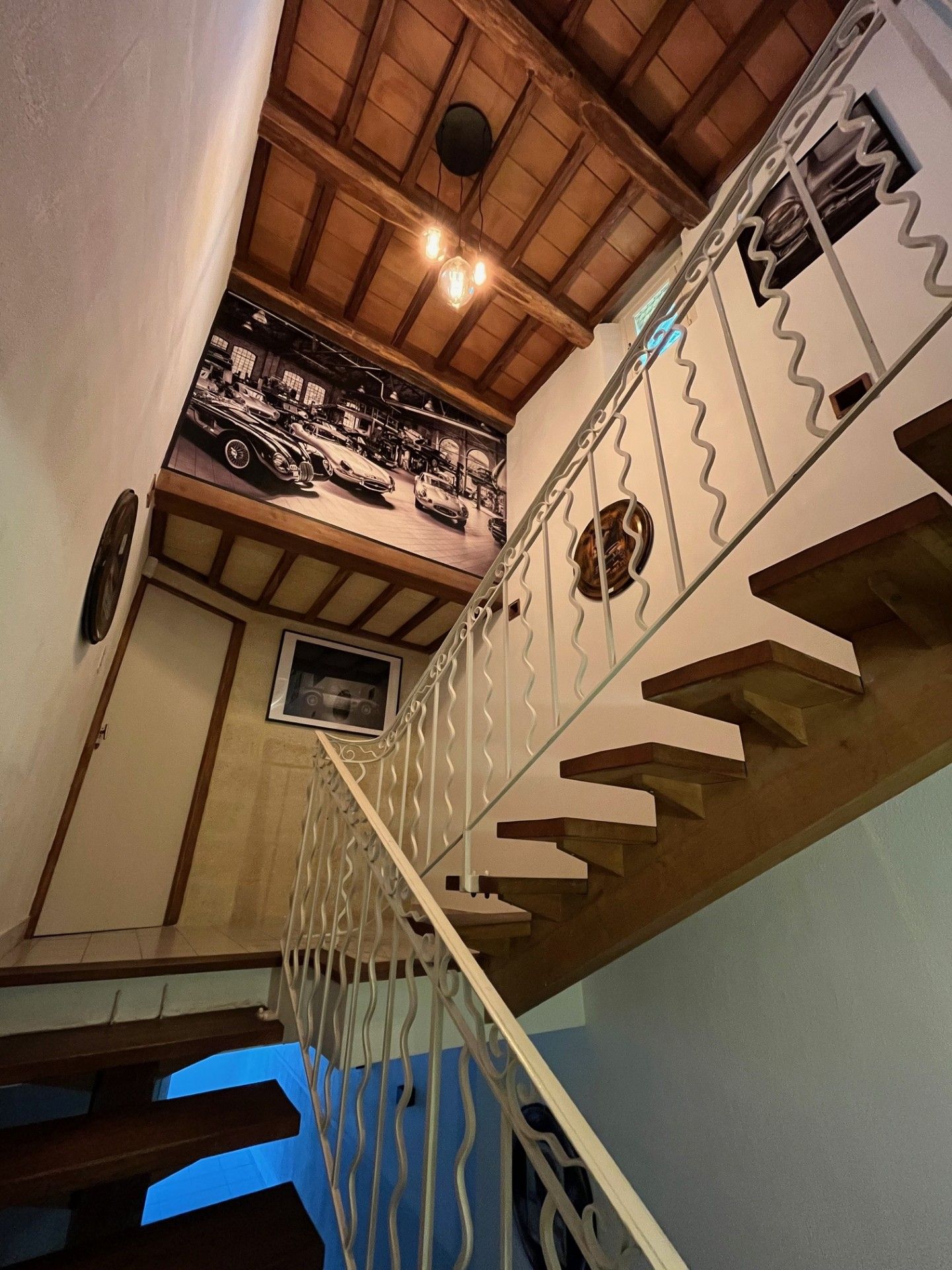 A staircase with a metal railing and a wooden ceiling.