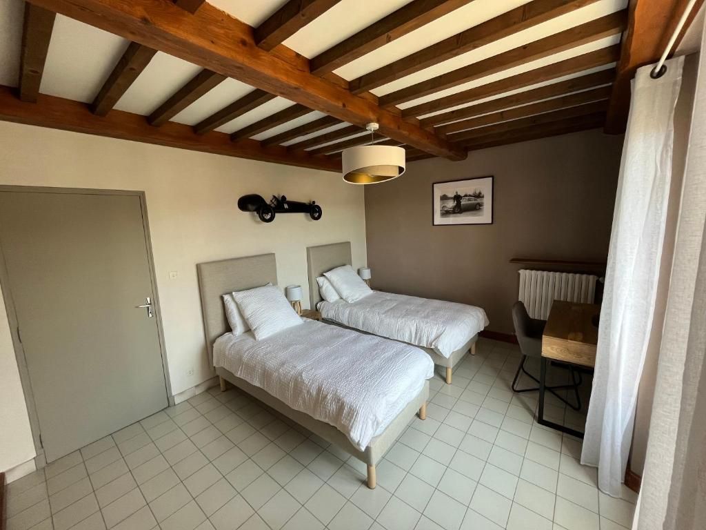 Una habitación con dos camas, un escritorio y una silla.