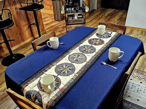 A dining table with a blue tablecloth, a decorative runner, and four white mugs. - Welcome To Blissful Relaxation In The Country 1 Bedroom Bed And Breakfast (Somerville)