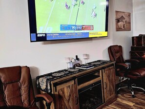 A living room with a flat-screen TV mounted on the wall, a wooden entertainment center, leather armchairs, and a fireplace. - Welcome To Blissful Relaxation In The Country 1 Bedroom Bed And Breakfast (Somerville)