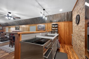 Eine moderne Küche mit Einbauherd, Spüle und einer Holztischinsel.