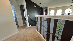 A hallway with a carpeted floor, a staircase with a railing, and a wall with a tree mural. - Attention Star Wars Fans! Amazing 6 Br Pool 6 Bedroom Villa (Kissimmee)