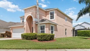A single-story house with a garage, a large arched entryway, and a well-maintained lawn. - Attention Star Wars Fans! Amazing 6 Br Pool 6 Bedroom Villa (Kissimmee)