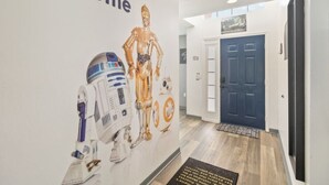 A hallway with a Star Wars-themed wall art, a blue door, and a welcome mat. - Attention Star Wars Fans! Amazing 6 Br Pool 6 Bedroom Villa (Kissimmee)