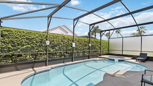 An indoor swimming pool with a glass enclosure, surrounded by lounge chairs and a hedge. - Attention Star Wars Fans! Amazing 6 Br Pool 6 Bedroom Villa (Kissimmee)