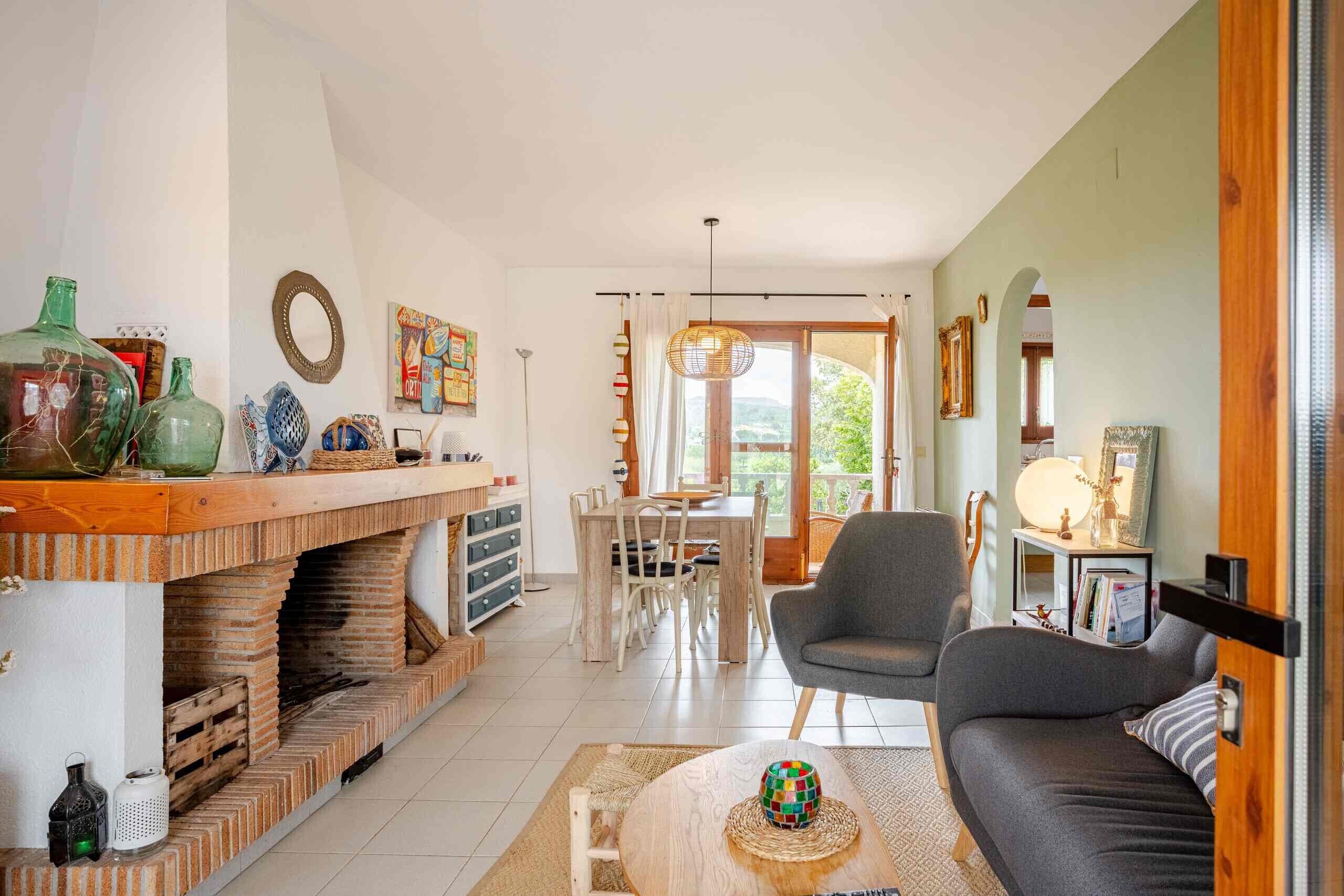 Een woonkamer met een open haard, eethoek en een bank.
