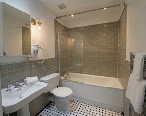 Ein Badezimmer mit Badewanne, Toilette und Waschbecken.