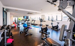 A gym with various exercise equipment, including treadmills, stationary bikes, and free weights. - Modern living, prime location, everything within easy reach - Broadbeach stay. (Broadbeach)