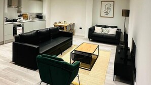 Un soggiorno moderno con un divano, un tavolino da caffè e una televisione.