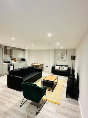 Ein zeitgemäßer Wohnraum mit Sofa, Couchtisch und Fernseher.