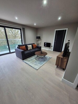 A modern living room with a sofa, coffee table, and a TV stand. - #22 Lux Apart balcony 11|Near NEC & BHX|for 4 (Birmingham)