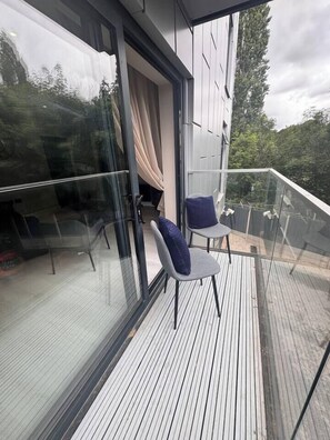 A balcony with a glass door, two chairs, and a view of trees. - #23 Lux Flatbalcony|10mins to ResortsWorldBHM|for4 (Birmingham)
