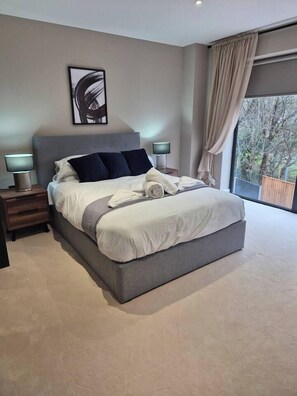 A modern bedroom with a large bed, bedside lamps, a window with curtains, and a painting on the wall. - #23 Lux Flatbalcony|10mins to ResortsWorldBHM|for4 (Birmingham)
