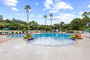 Ein Swimmingpool mit Liegestühlen und Palmen.