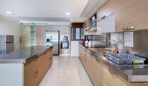 A modern kitchen with stainless steel appliances, wooden cabinetry, and a built-in oven. - Seafront 3BR home opposite beach in central Sliema (Sliema)