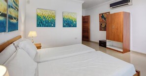 A bedroom with a bed, a nightstand, a lamp, and artwork on the wall. - Seafront 3BR home opposite beach in central Sliema (Sliema)
