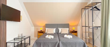 Une chambre à coucher avec un grand lit, deux tables de chevet, une télévision et une armoire.