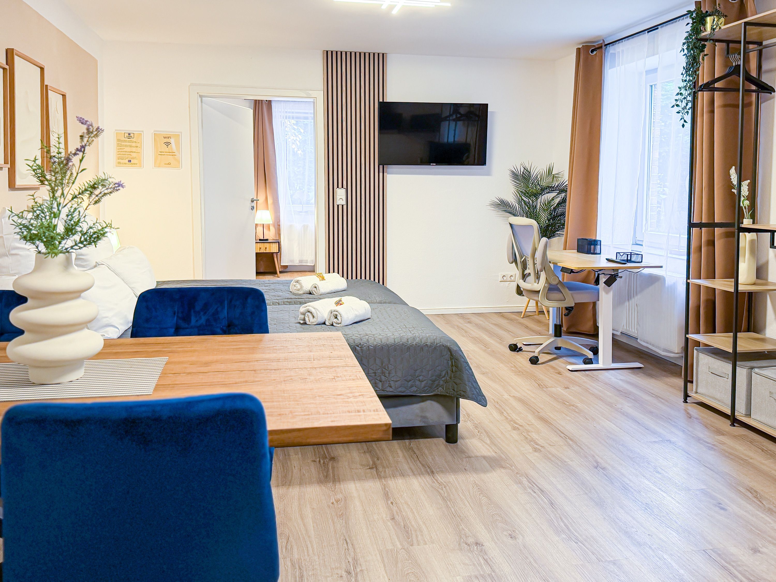 Une chambre d’hôtel moderne équipée d’un lit, d’un bureau, d’une chaise, d’une télévision et d’une bibliothèque.