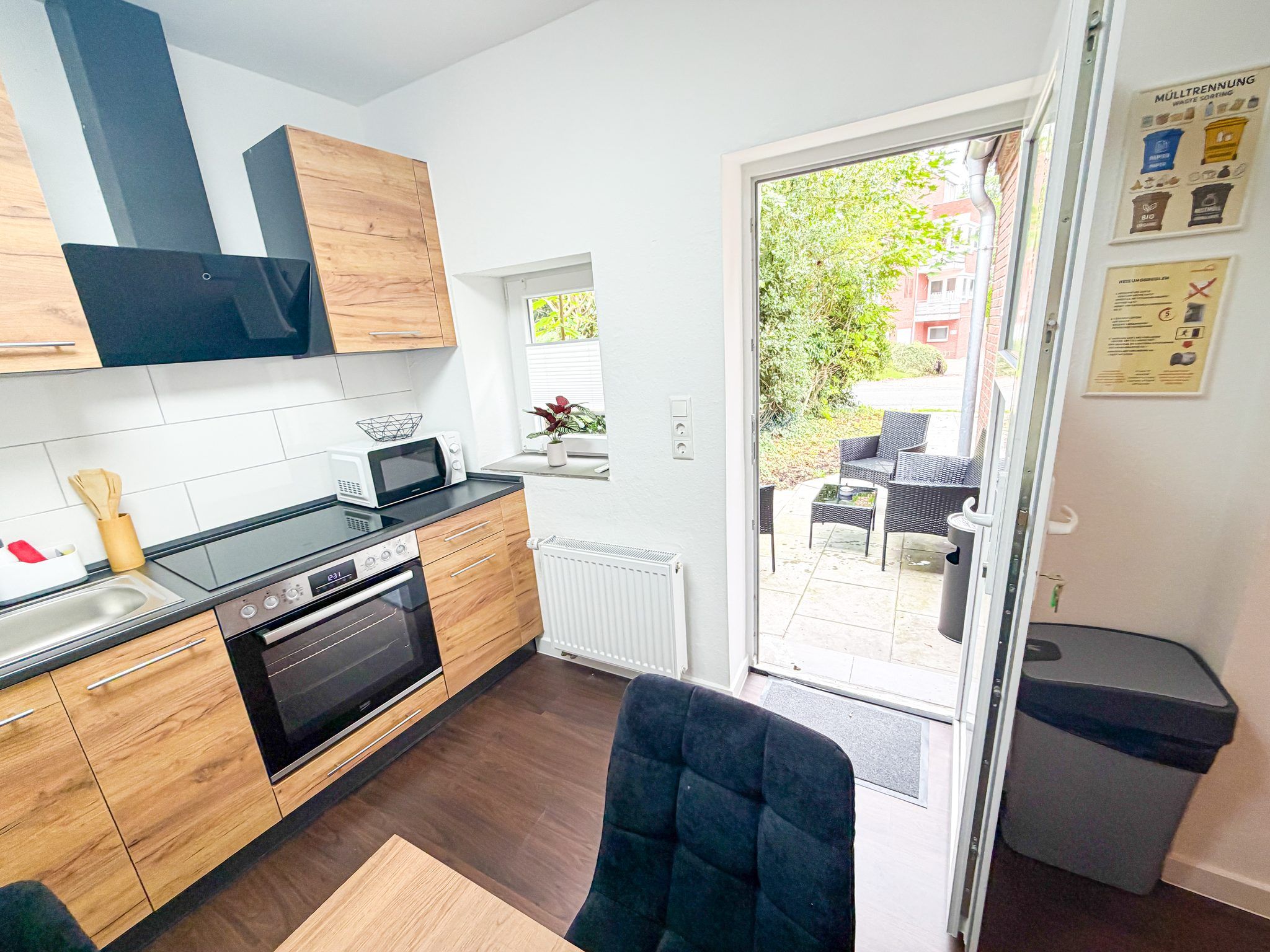 A modern kitchen with wooden cabinets, a built-in oven, and a microwave.