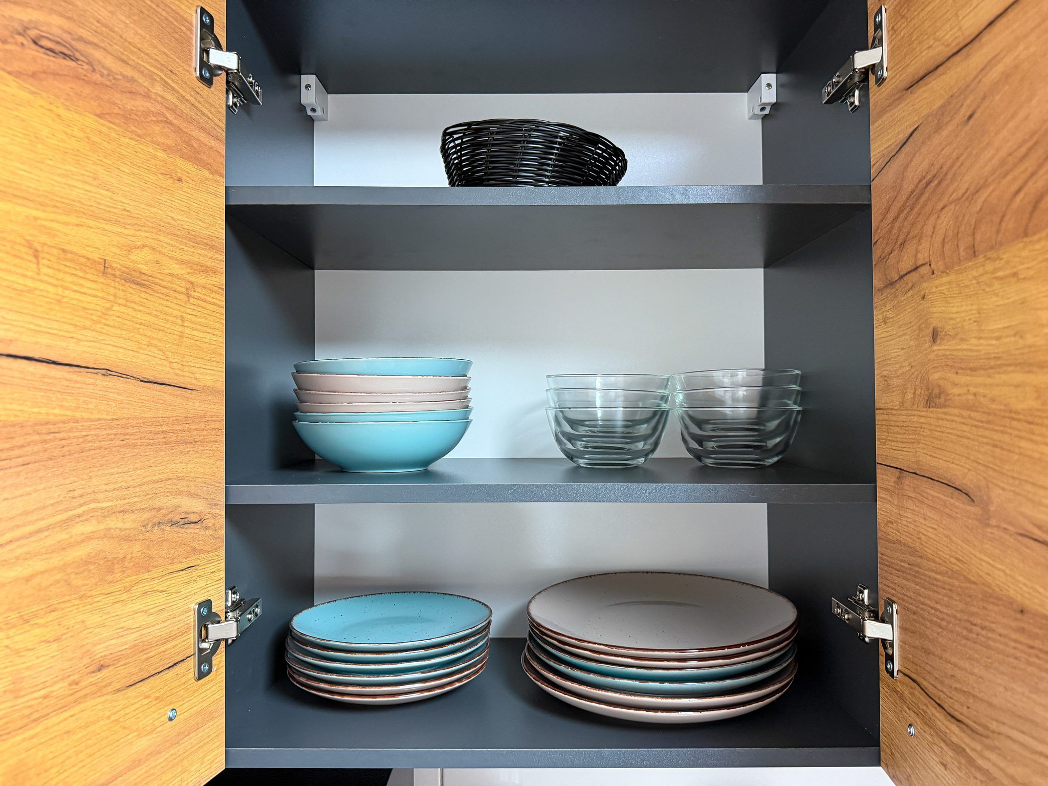A cabinet with multiple shelves containing various kitchenware items.