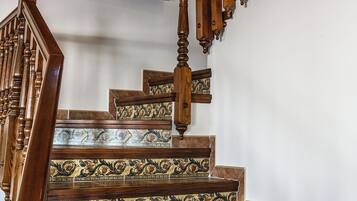 Una escalera de madera con barandillas ornamentales y un diseño de azulejos decorativos en los peldaños.