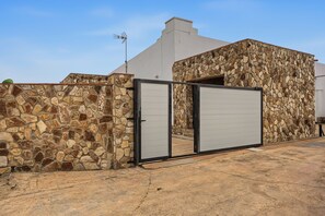 A building with a stone facade and a metal gate. - Holiday Home 'La Chumbera' with Shared Pool and Private Terrace (Vejer de la Frontera)