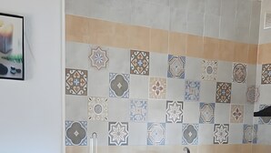A kitchen with a stone backsplash, a wooden chair, and a sink. - Holiday Home 'Casa El Arriate' with Shared Pool and Private Terrace (Vejer de la Frontera)