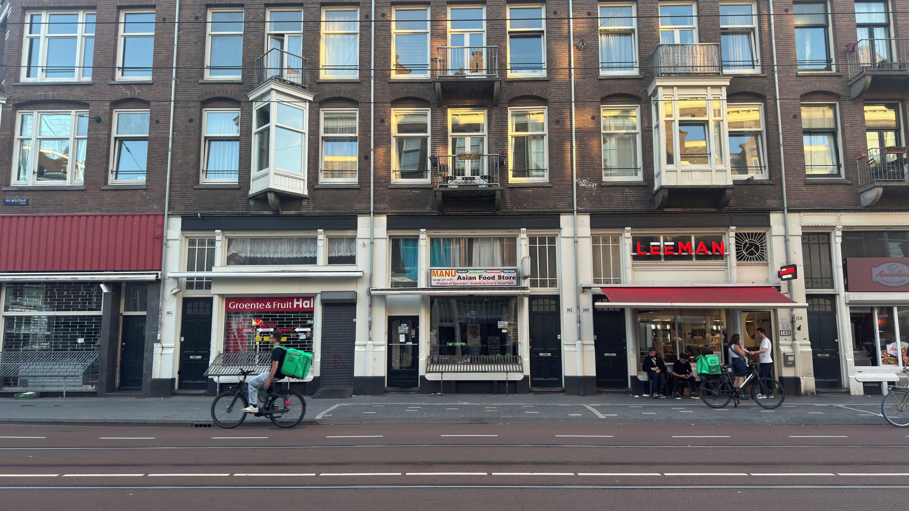 A multi-story building with various storefronts, including a grocer and a food store.