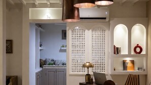 A modern kitchen with a marble dining table, pendant lights, and a laptop on the counter. - Charming riad with a private rooftop and pool | In the heart of the Medina (Marrakesh)