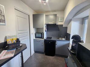 A compact kitchenette with a microwave, sink, and dishwasher. - Charming apartment in the city centre (Luxeuil-les-Bains)