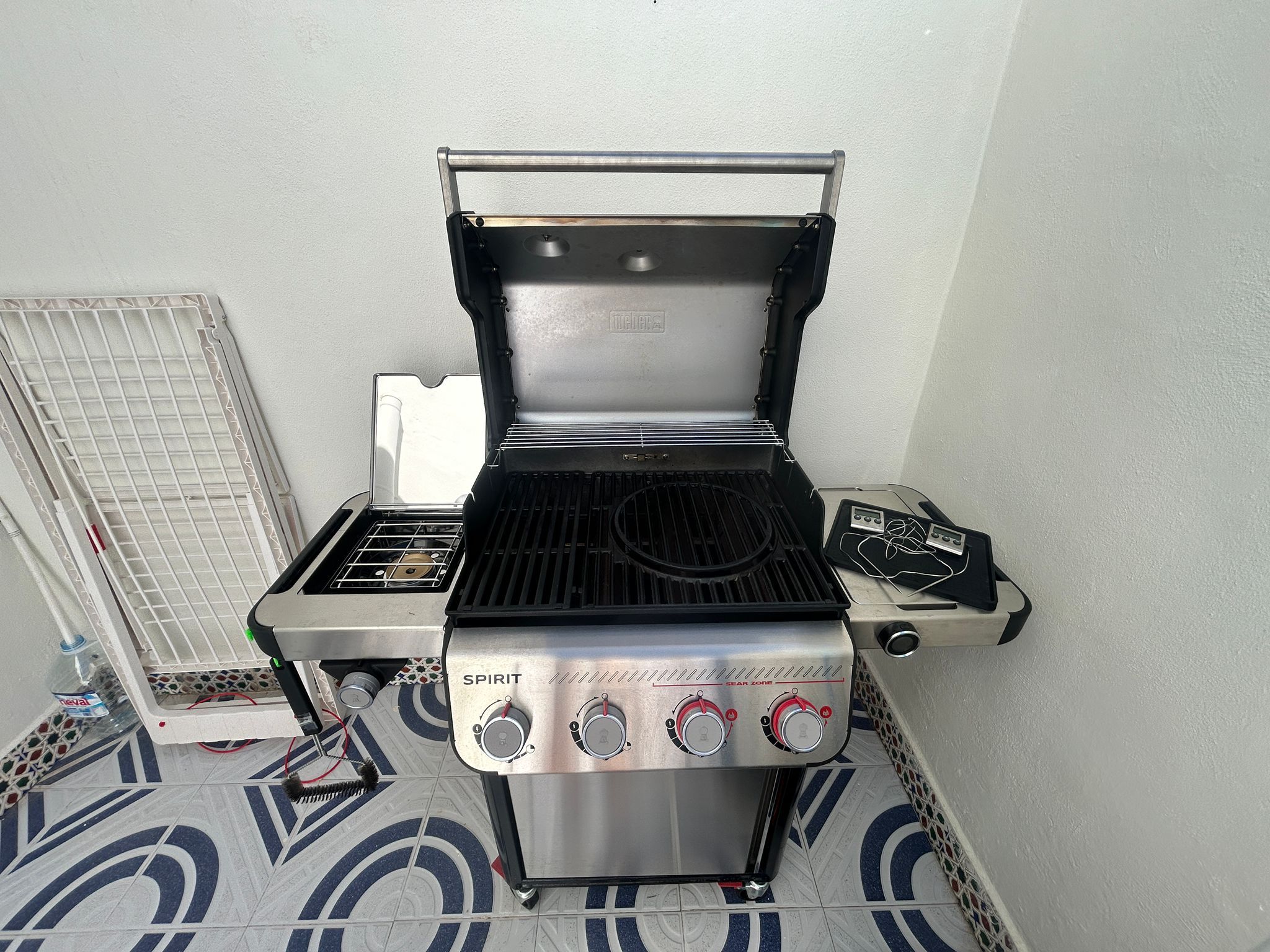 Een kleine keuken met een ingebouwde gasplaat, een grill en een waterdispenser.