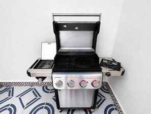 Ein tragbarer Gasgrill mit digitaler Anzeige, mehreren Brennern und einem Seitenbrenner.