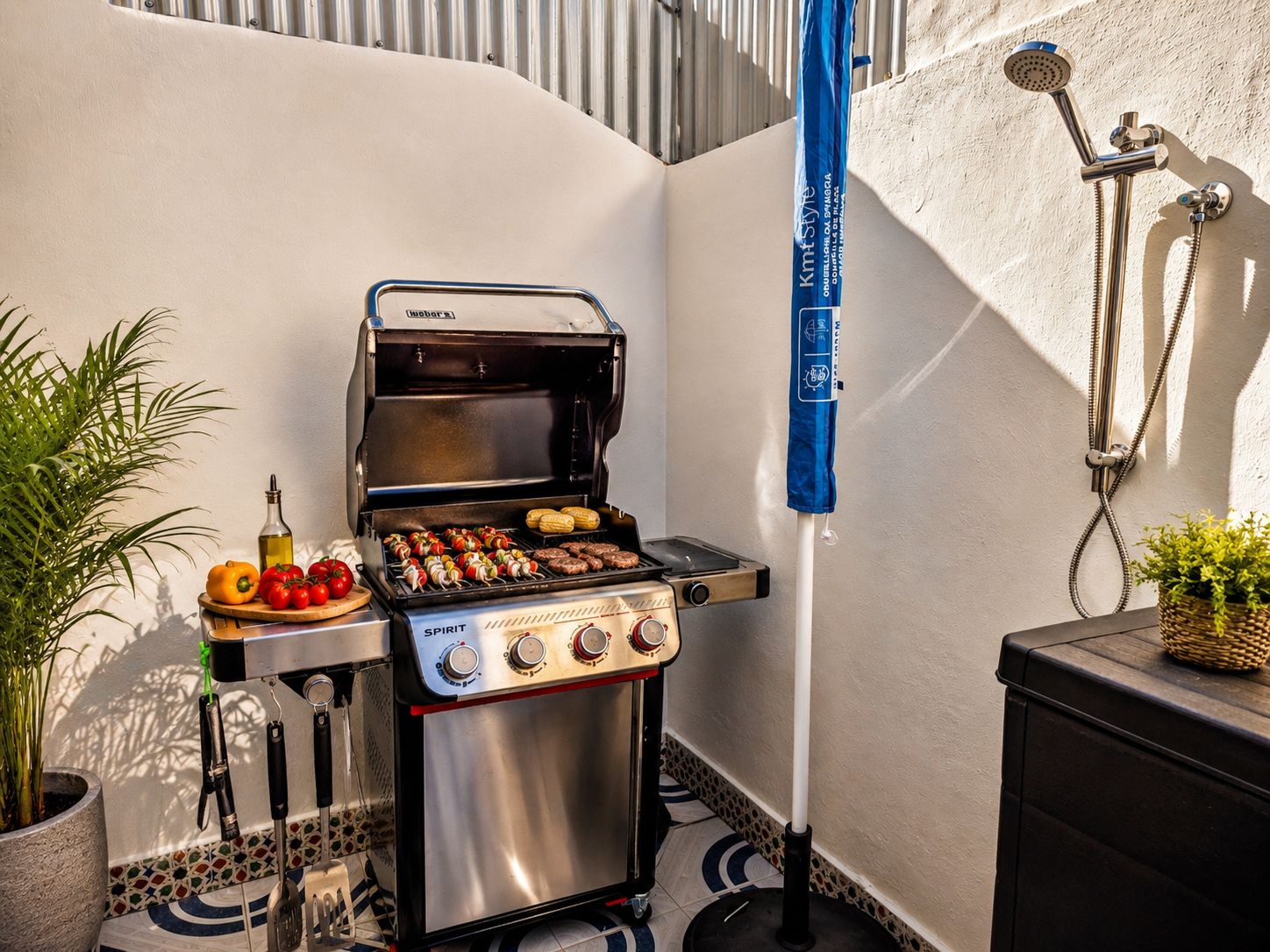 A compact outdoor kitchen with a grill, a portable gas stove, and a built-in water heater.
