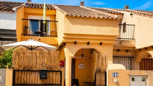A residential building with a covered patio, a balcony, and a gate. - Villa Jenny – Privates Küstenhaus in Los Alcázares (Los Alcázares)