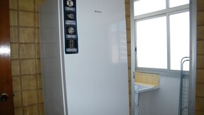 A white refrigerator with a control panel featuring energy and smart digital control icons, a reversible door, and a window above it. - Family apartment, sea view, pets welcome - 6 guests (Gandia)