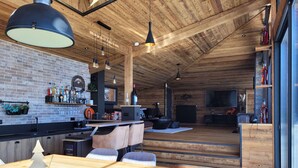 Una cocina moderna con pared de ladrillo, techo de madera y barra con taburetes.