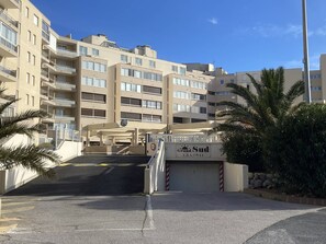 Ein mehrgeschossiges Gebäude mit Balkonen, einem verschlossenen Eingang und einem Schild mit der Aufschrift 'Grand Sud'.