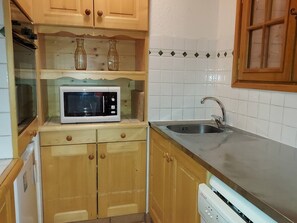A kitchen with wooden cabinets, a microwave, a sink, and a dishwasher. - Cozy apartment in Valmorel center - 4 guests (Valmorel)