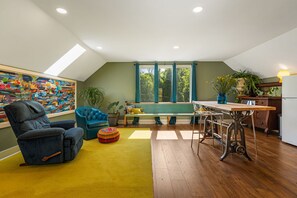 A modern loft with a dining area, a large abstract painting, and a view of trees through the windows. - King Studio, Fast WIFI, Peaceful, Secluded Nature, Pets (Alexander)