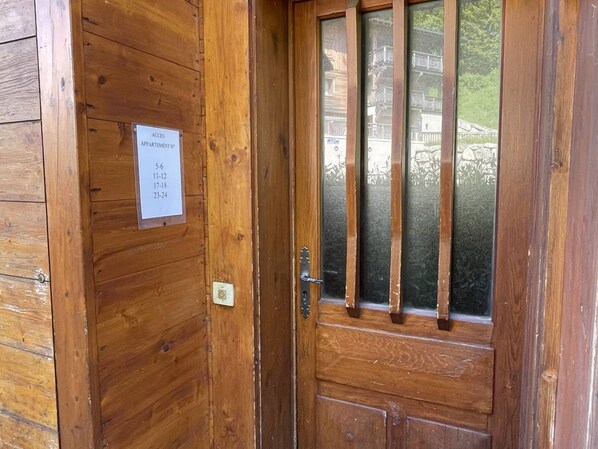 A wooden door with a frosted glass window and a sign indicating room access times.