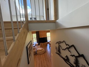 A multi-level interior with wooden floors, a staircase, and a view of the outdoors. - Cosy apartment with mountain view - 7 guests (Valmorel)